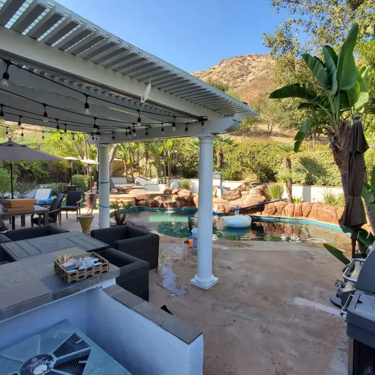 Backyard oasis with pool, lounge area, and mountain backdrop under a clear blue sky.